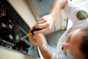 A Mister Sparky Rogers Electrician fixes an electrical main panel.